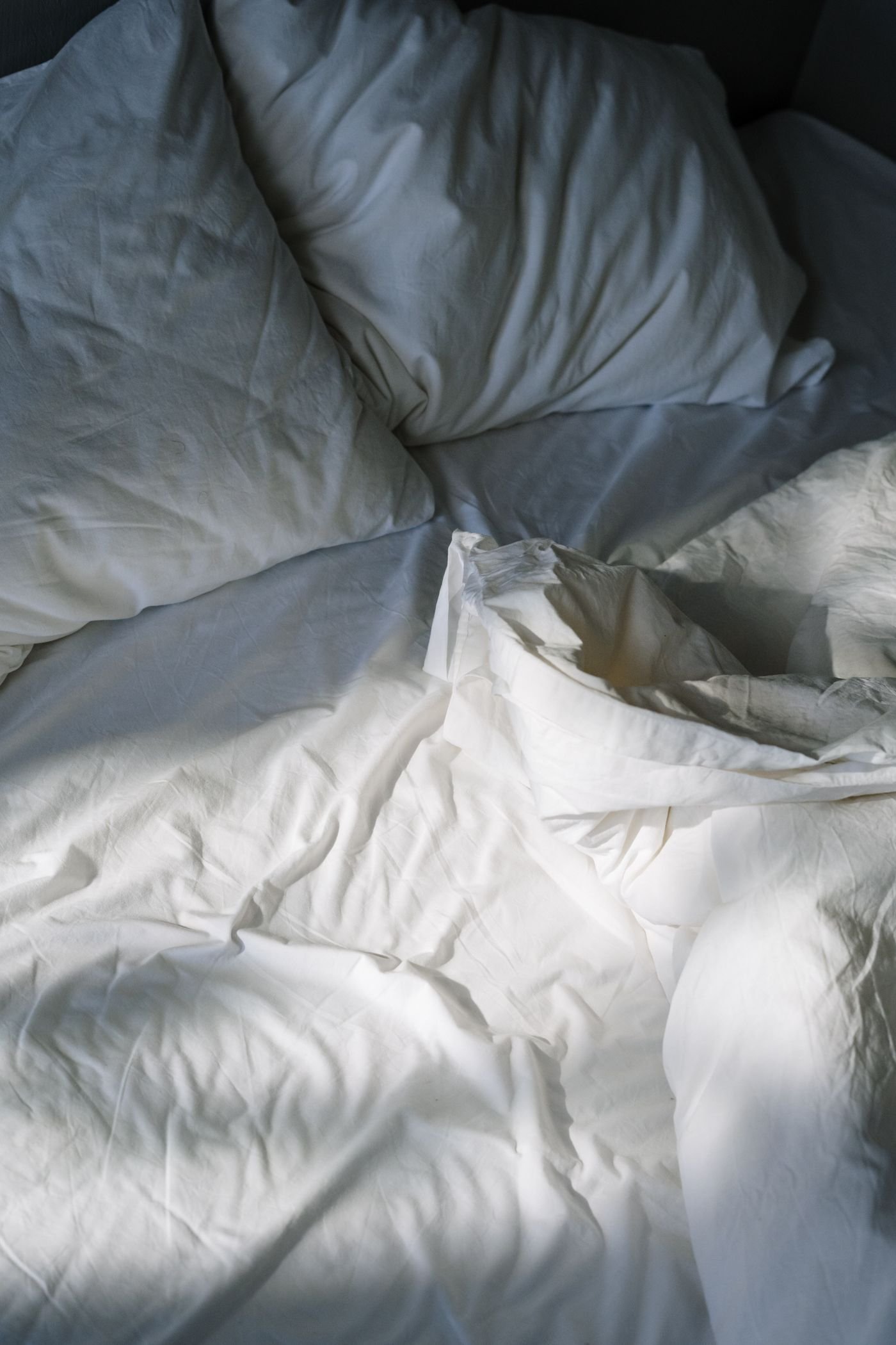 Ropa de cama blanca iluminada por luz natural